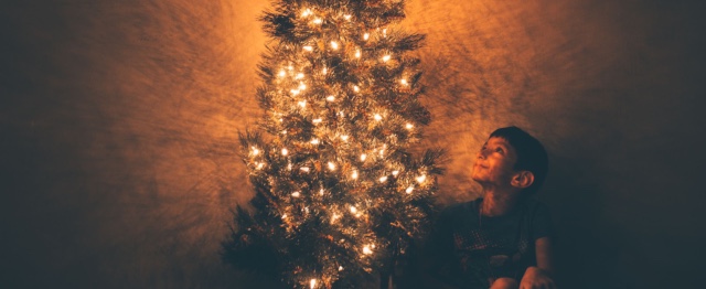Kerst, jongen bij kerstboom